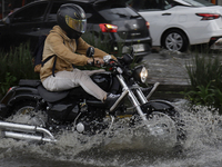 Motorcyclists are riding along Avenida Tlahuac in Mexico City after flooding is reported in various areas of the capital. (