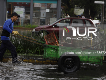 A person is trying to cross the street after flooding in various areas of Mexico City (