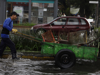 A person is trying to cross the street after flooding in various areas of Mexico City (