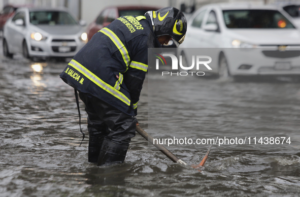 A firefighter is trying to unclog a drain after flooding is reported in various areas of Mexico City. 