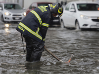 A firefighter is trying to unclog a drain after flooding is reported in various areas of Mexico City. (