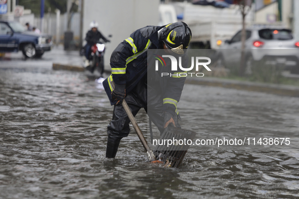 A firefighter is trying to unclog a drain after flooding is reported in various areas of Mexico City. 