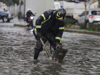 A firefighter is trying to unclog a drain after flooding is reported in various areas of Mexico City. (