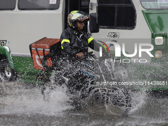 Motorcyclists are riding along Avenida Tlahuac in Mexico City after flooding is reported in various areas of the capital. (