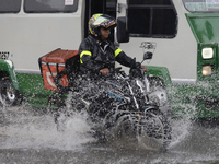 Motorcyclists are riding along Avenida Tlahuac in Mexico City after flooding is reported in various areas of the capital. (