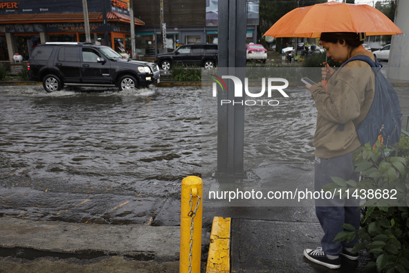 A person is trying to cross the street after flooding in various areas of Mexico City 