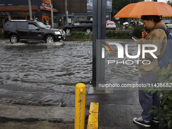 A person is trying to cross the street after flooding in various areas of Mexico City (