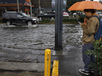 A person is trying to cross the street after flooding in various areas of Mexico City (