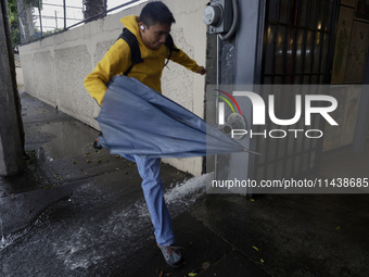 A person is trying to cross the street after flooding in various areas of Mexico City, Mexico. (