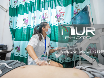 A doctor is using an instrument to treat a patient at the Second People's Hospital of Jinsha County in Bijie, China, on July 17, 2024. (