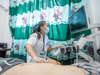 A doctor is using an instrument to treat a patient at the Second People's Hospital of Jinsha County in Bijie, China, on July 17, 2024. (