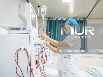 A doctor is performing hemodialysis treatment on a patient at the Second People's Hospital of Jinsha County in Bijie, China, on July 17, 202...