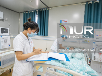 A doctor is performing hemodialysis treatment on a patient at the Second People's Hospital of Jinsha County in Bijie, China, on July 17, 202...