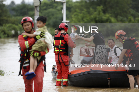 Rescue workers are moving trapped people in Jingtang village, Tangdong Subdistrict, Zixing city, Central China's Hunan province, on July 28,...