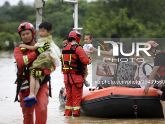 Rescue workers are moving trapped people in Jingtang village, Tangdong Subdistrict, Zixing city, Central China's Hunan province, on July 28,...