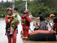 Rescue workers are moving trapped people in Jingtang village, Tangdong Subdistrict, Zixing city, Central China's Hunan province, on July 28,...