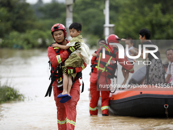 Rescue workers are moving trapped people in Jingtang village, Tangdong Subdistrict, Zixing city, Central China's Hunan province, on July 28,...