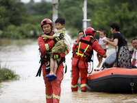 Rescue workers are moving trapped people in Jingtang village, Tangdong Subdistrict, Zixing city, Central China's Hunan province, on July 28,...