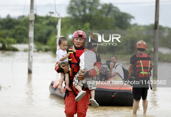 Rescue workers are moving trapped people in Jingtang village, Tangdong Subdistrict, Zixing city, Central China's Hunan province, on July 28,...