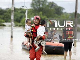 Rescue workers are moving trapped people in Jingtang village, Tangdong Subdistrict, Zixing city, Central China's Hunan province, on July 28,...