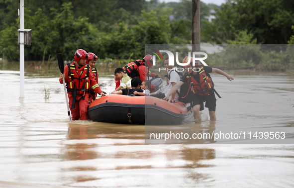 Rescue workers are moving trapped people in Jingtang village, Tangdong Subdistrict, Zixing city, Central China's Hunan province, on July 28,...