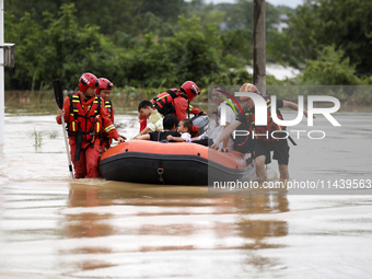 Rescue workers are moving trapped people in Jingtang village, Tangdong Subdistrict, Zixing city, Central China's Hunan province, on July 28,...