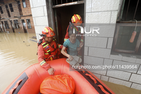 Rescue workers are moving trapped people in Jingtang village, Tangdong Subdistrict, Zixing city, Central China's Hunan province, on July 28,...