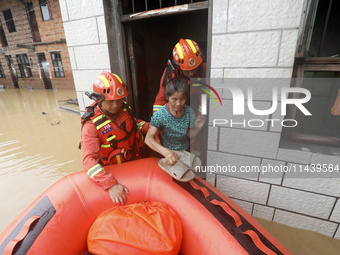 Rescue workers are moving trapped people in Jingtang village, Tangdong Subdistrict, Zixing city, Central China's Hunan province, on July 28,...