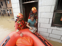 Rescue workers are moving trapped people in Jingtang village, Tangdong Subdistrict, Zixing city, Central China's Hunan province, on July 28,...