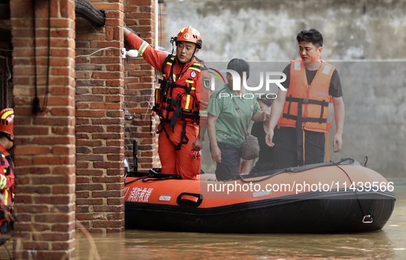 Rescue workers are moving trapped people in Jingtang village, Tangdong Subdistrict, Zixing city, Central China's Hunan province, on July 28,...