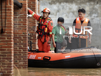 Rescue workers are moving trapped people in Jingtang village, Tangdong Subdistrict, Zixing city, Central China's Hunan province, on July 28,...