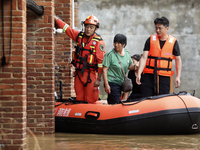 Rescue workers are moving trapped people in Jingtang village, Tangdong Subdistrict, Zixing city, Central China's Hunan province, on July 28,...