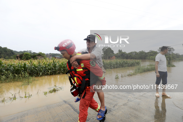 Rescue workers are moving trapped people in Jingtang village, Tangdong Subdistrict, Zixing city, Central China's Hunan province, on July 28,...