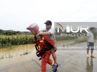 Rescue workers are moving trapped people in Jingtang village, Tangdong Subdistrict, Zixing city, Central China's Hunan province, on July 28,...