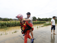 Rescue workers are moving trapped people in Jingtang village, Tangdong Subdistrict, Zixing city, Central China's Hunan province, on July 28,...