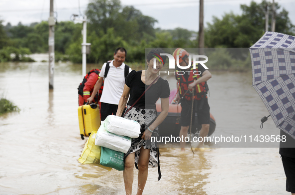 Rescue workers are moving trapped people in Jingtang village, Tangdong Subdistrict, Zixing city, Central China's Hunan province, on July 28,...