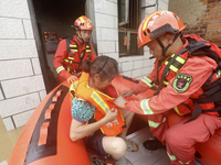 Rescue workers are moving trapped people in Jingtang village, Tangdong Subdistrict, Zixing city, Central China's Hunan province, on July 28,...