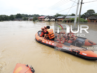 Rescue workers are moving trapped people in Jingtang village, Tangdong Subdistrict, Zixing city, Central China's Hunan province, on July 28,...