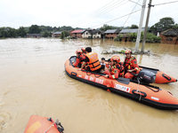 Rescue workers are moving trapped people in Jingtang village, Tangdong Subdistrict, Zixing city, Central China's Hunan province, on July 28,...