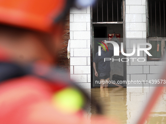 Rescue workers are moving trapped people in Jingtang village, Tangdong Subdistrict, Zixing city, Central China's Hunan province, on July 28,...