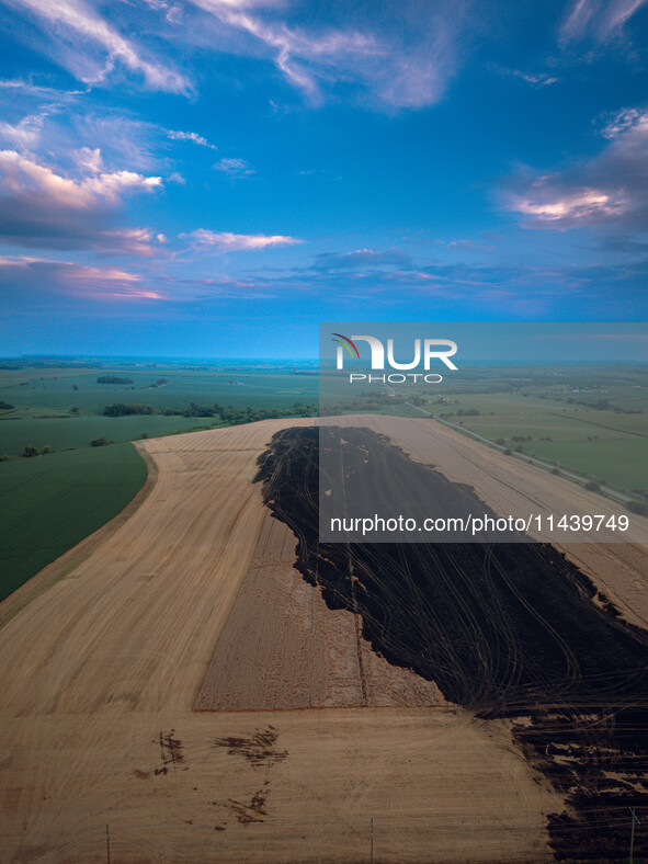 A combine is sparking a devastating fire in a wheat field in Orangeville, IL, rapidly spreading and engulfing a significant portion of the c...