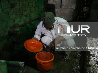 A man is filling a bucket with water on a hot summer evening in Srinagar, Jammu and Kashmir, on July 28, 2024. Kashmir is reeling under an i...