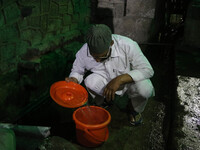 A man is filling a bucket with water on a hot summer evening in Srinagar, Jammu and Kashmir, on July 28, 2024. Kashmir is reeling under an i...