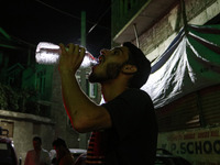 A man is drinking water outside his home on a hot summer evening in Srinagar, Jammu and Kashmir, on July 28, 2024. Kashmir is reeling under...