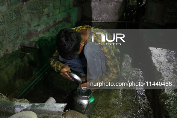 A boy is filling a steel bucket with water on a hot summer evening in Srinagar, Jammu and Kashmir, on July 28, 2024. Kashmir is reeling unde...