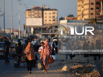 Displaced Palestinians are leaving al-Bureij refugee camp towards the west, after the Israeli army issued a new evacuation order, in the cen...