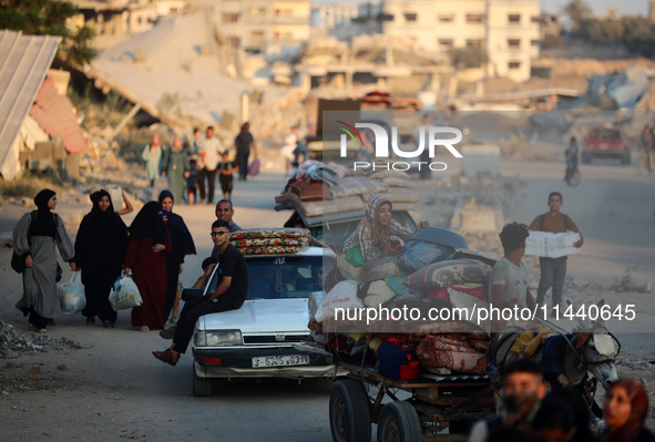 Displaced Palestinians are leaving al-Bureij refugee camp towards the west, after the Israeli army issued a new evacuation order, in the cen...