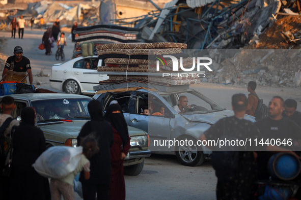 Displaced Palestinians are leaving al-Bureij refugee camp towards the west, after the Israeli army issued a new evacuation order, in the cen...