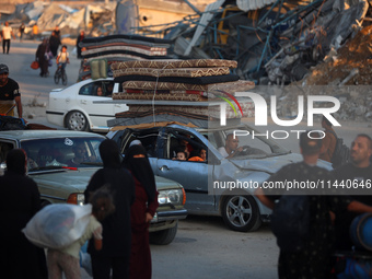 Displaced Palestinians are leaving al-Bureij refugee camp towards the west, after the Israeli army issued a new evacuation order, in the cen...