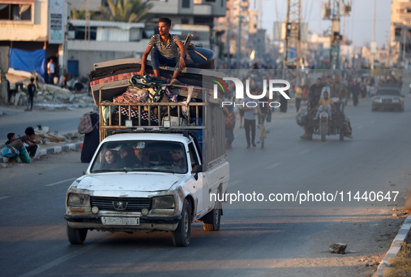 Displaced Palestinians are leaving al-Bureij refugee camp towards the west, after the Israeli army issued a new evacuation order, in the cen...